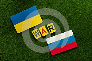Ukraine Vs Russia. Symbol flags on a green lawn background