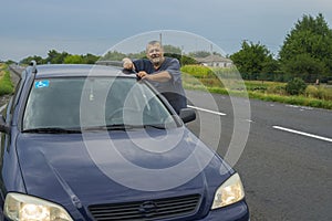 Ukrainian bearded senior standing near his car on dnipro-poltava highway