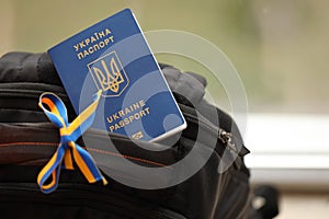 Ukrainian biometrical passport on black touristic backpack with ukrainian ribbon