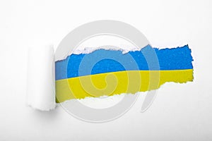 Ukrainian blue and yellow flag in the hole in paper