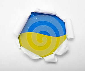 Ukrainian blue and yellow flag in the round hole in paper