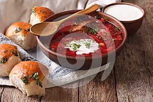 Ukrainian borscht red soup with garlic buns on the table. horizontal photo