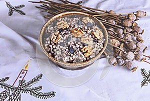 Ukrainian Christmas dish kutia, wheat porridge with nuts, poppy seeds, raisins on a white tablecloth.