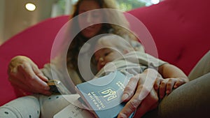 A Ukrainian family is sitting at the airport in a red chair, waiting for their flight to their destination country