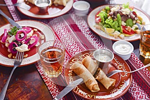 Ukrainian family in traditional closes has a dinner. Ukrainian culture. Family eating and clang glasses together.