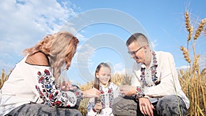 Ukrainian family in a wheat field in traditional national clothes Vyshyvanka.