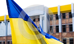 Ukrainian flag on the background of unfinished building.