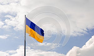 Ukrainian flag blowing on the wind with free sky background space