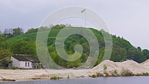 Ukrainian flag fluttering over Devich Mountain in Trypillia village