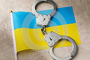Ukrainian flag and handcuffs on an abstract background, a concept on the topic of crime in the country