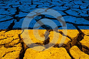 Ukrainian flag over cracked ground