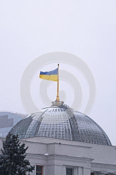 Ukrainian flag waving over Parliament Verkhovna Rada of Ukraine in Kiev, Ukraine. Snowfall morning photo