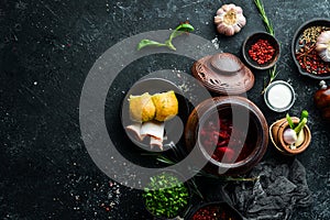Ukrainian food. Borsch with lard, garlic and donuts on a black stone background. Top view. Rustic style photo