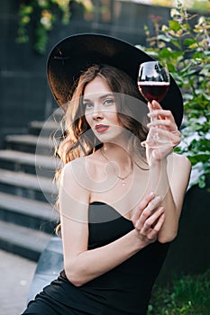 Ukrainian girl in a black dress outdoors in a hat