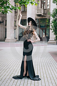 Ukrainian girl in a black dress outdoors in a hat