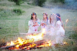 Ukrainian girl in shirts sitting around the campfire