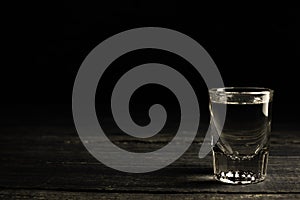 Ukrainian gorilka or vodka or tequila or rum (transparent highly alcoholic drink) shot on dark background.