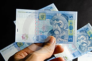 The Ukrainian hryvnia denominated five, ten, twenty hryvnias scattered and neatly linked. Hryvnia in male hands and in a wallet.