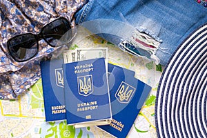 Ukrainian international passport with cash, tatter jeans, hat, on map background. Preparing luggage for traveling photo