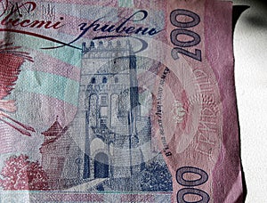 Ukrainian money. Banknote of Ukrainian hryvnia. Background of two hundred hryvnia banknotes, coins in piles, close-up