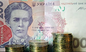 Ukrainian money. Banknote of Ukrainian hryvnia. Background of two hundred hryvnia banknotes, coins in piles, close-up
