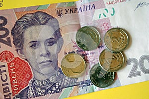 Ukrainian money. Banknote of Ukrainian hryvnia. Background of two hundred hryvnia banknotes, coins in piles, close-up