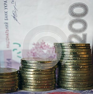 Ukrainian money. Banknote of Ukrainian hryvnia. Background of two hundred hryvnia banknotes, coins in piles, close-up