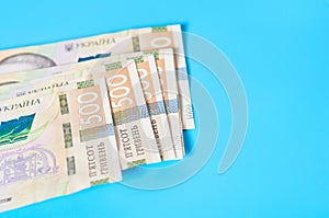 Ukrainian money on blue background. Payment of pensions, salaries