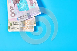 Ukrainian money on blue background. Payment of pensions, salaries