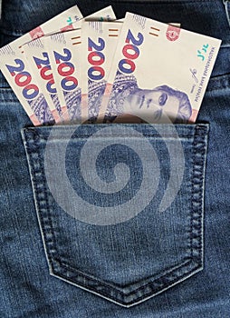 Ukrainian money. New banknotes 200 two hundred hryvnia bills UAH in the back pocket of blue jeans. Money concept, Corruption