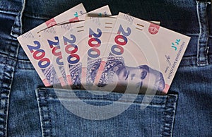 Ukrainian money. New banknotes 200 two hundred hryvnia bills UAH in the back pocket of blue jeans. Money concept, Corruption