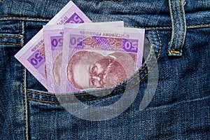 Ukrainian money in a pocket of blue jeans