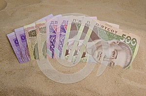 Ukrainian money in sand