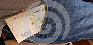 Ukrainian money stacked in a pocket of jeans trousers