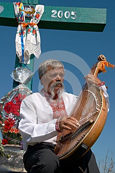 Ukrainian musician with bandura under cross 2