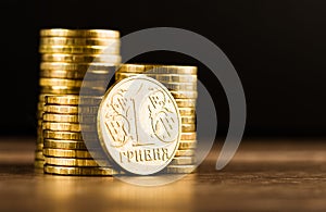 Ukrainian one hryvnia coin and gold money on the desk