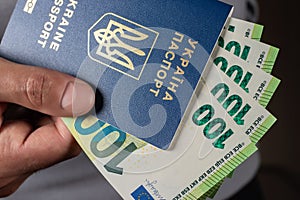 ukrainian passport and 100 euro banknotes in hand