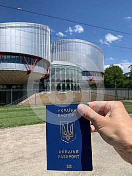 Ukrainian passport against the background of the building of the European Court of Human Rights. Strasbourg, France