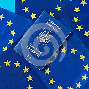 Ukrainian passport against the background of many flags of the European Union, the concept, close-up