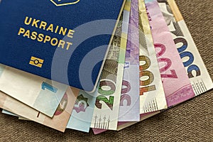 Ukrainian passport and money, Ukrainian hryvna banknotes bills on copy space background, top view. Traveling and finance problems