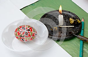 Ukrainian pisanka with a tool, candle, piece of wax