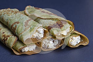 Ukrainian and Russian dishes - homemade pancakes with green spirulina stuffed white cottage cheese with raisins