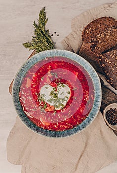 Ukrainian and Russian traditional beet soup borsh with sour cream in a bowl. Close-up photo