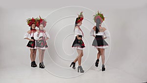 Ukrainian sexy show teem dancing in national costumes white background in studio