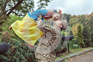 Ukrainian soldier is holding his daughter in his arms