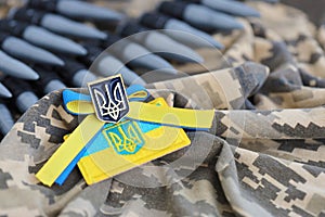 Ukrainian symbol and a machine gun belt on the camouflage uniform of a Ukrainian soldier. The Concept of war in Ukraine