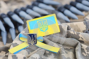 Ukrainian symbol and a machine gun belt on the camouflage uniform of a Ukrainian soldier. The Concept of war in Ukraine