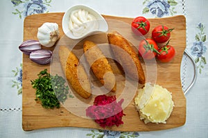 Ukrainian tradition food on a wooden board . Red cabbage sauerkraut in a small bowl . mashed potatoes . Mayonnaise, Garlic, Onion