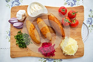 Ukrainian tradition food on a wooden board . Red cabbage sauerkraut in a small bowl . mashed potatoes . Mayonnaise, Garlic, Onion