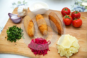 Ukrainian tradition food on a wooden board . Red cabbage sauerkraut in a small bowl . mashed potatoes . Mayonnaise, Garlic, Onion